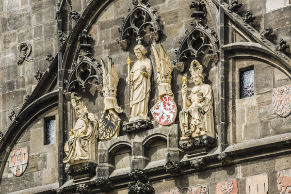 Nejvýznamnější část Staroměstské mostecké věže, pojaté jako triumfální oblouk, zdobí kromě erbů historických zemí sochy císaře Karla IV., svatého Víta a římského krále Václava IV. (v současnosti pískovcové repliky)