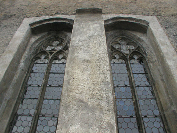 Dvojice gotických kroužkových oken tzv. malé Rožmberské kaple s opěrným pilířem (stav po konzervaci, 2004)