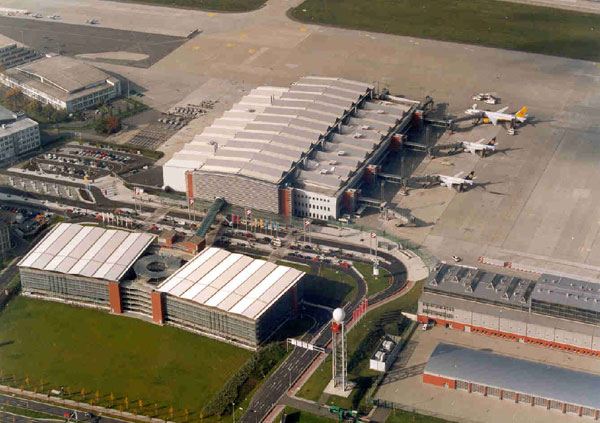 Hotový terminál letiště v Drážďanech s nástupními mosty pro letadla a protilehlý parkovací dům 