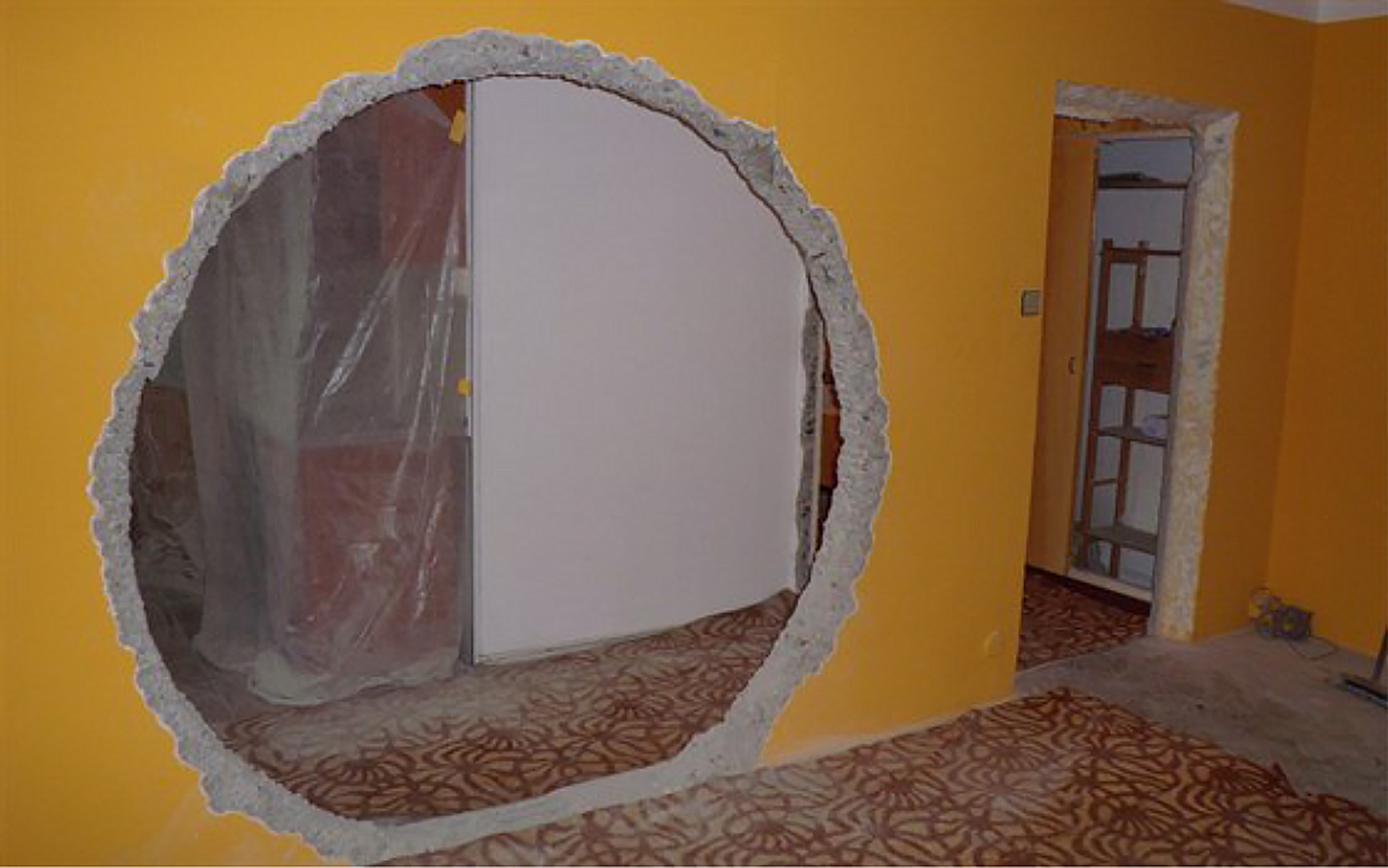 Příklad závažného oslabení panelové nosné stěny dodatečně zřízeným otvorem průměru 2 m a rozšířením dveřního otvoru