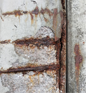 Obr. 2 Opadávající krycí vrstva betonu stěnových dílců způsobená zatékáním slané vody a následnou chloridovou korozí výztuže
